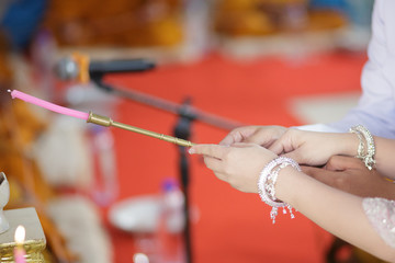 Bride and groom are fire at candle in wedding ceremony