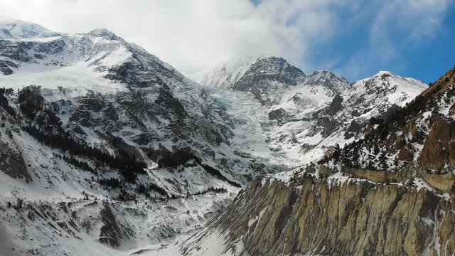Aerial drone shot of the Glacier between Annapurna and Gangapurna Mountains panning towards empty moraine lake in Manang valley, Nepal.