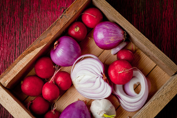 Red onion, radish and head of garlic. Background for cooking. Vegetables. Healthy nutrition, vitamins and vegetarianism.