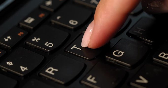 Pushing T button on the black keyboard. English letters. Used Macro lens and slow-mo.