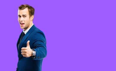 Excited businessman showing thumbs up like hand sign gesture, in blue confident suit, over purple...