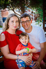 Young average family of three on vacation by the sea