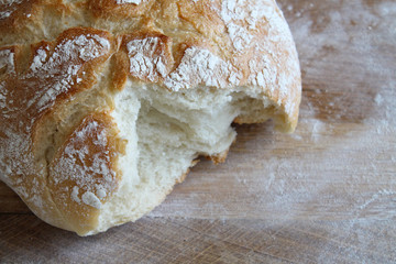 Rustic loaf of homemade bread close up on wooden board. Overhead view