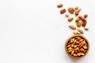 Mixed nuts in bowl - healthy snack - on white background top-down frame copy space