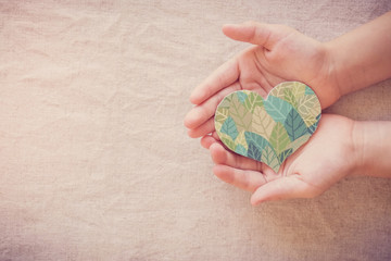 Hands holding leaf heart shape, CSR social responsibility, eco sustainable living, vegan, world...