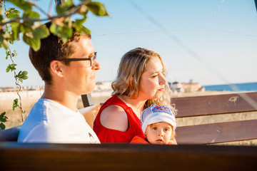 Young average family of three on vacation by the sea