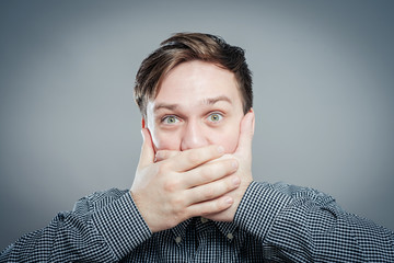 Emotional man keep his mouth closed by his hands