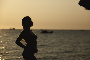 girl on vacation near the beach meets the sunset