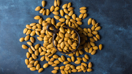 Almonds on a clay pot with nice blue background. Top view. Copy space. Healthy food concept 