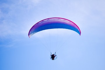 Aircraft parachute with a motor. Man with paraglider fly in the blue sky.