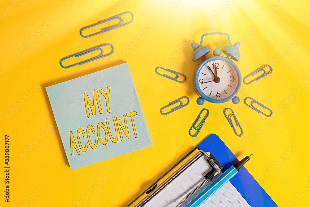 Fototapete Handwriting text writing My Account. Conceptual photo If something is said to be on someone s is or something s is account Metal alarm clock clipboard clips ballpoint notepad colored background