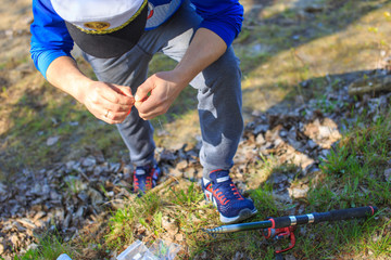 Fisherman preparing bait on fishing rod on lakeside in the morning