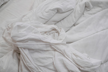 White delicate soft background of fabric or bedding sheet in dark room.