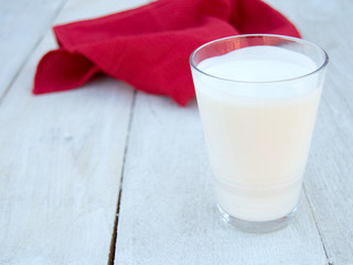 Glass of kefir or buttermilk on a white wooden background. Fermented dairy product with probiotics. Useful drink for preserving your figure and diet.