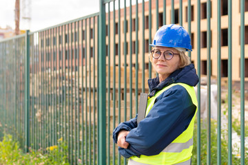 A female builder worker inspects a construction site.