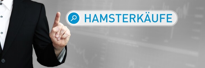 Hamsterkäufe. Mann im Anzug zeigt mit dem Finger auf ein Suchfeld. Der Begriff Hamsterkäufe steht in der Suche. Symbol für Business, Finanzen, Statistik, Analyse, Wirtschaft