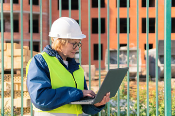 A female builder worker inspects a construction site.