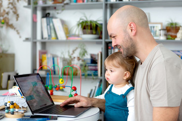 Young attractive father freelance worker working home with baby