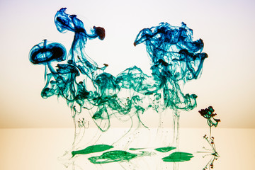 blaue Tinte in einer transparenten Flüssigkeit vor weißem Hintergrund