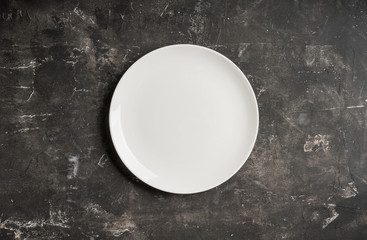 Clean white plate on the rustic background. Selective focus. Shot from above.