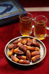 Dates fruit and Islamic Book Koran on carpet background, Islamic background in mosque