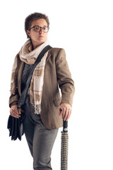 A woman with a short haircut, in a light jacket and with a light scarf around her neck, with a bag posing on a white background in the studio. Copy space.