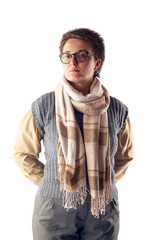 A woman with glasses and a short haircut, in a gray knitted vest, in a shirt and with a scarf around her neck poses on a white background in the studio.
