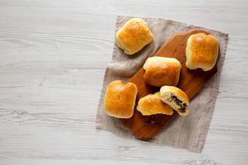 Home-baked Beef Russian Bierocks on a rustic wooden board on a white wooden surface, top view. Flat...