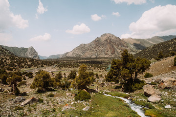 Middle Asia. Tajikistan. Fann mountains. Summer. Beautiful mountain landscape. A small mountain river flows through a mountain valley against the backdrop of the mountain