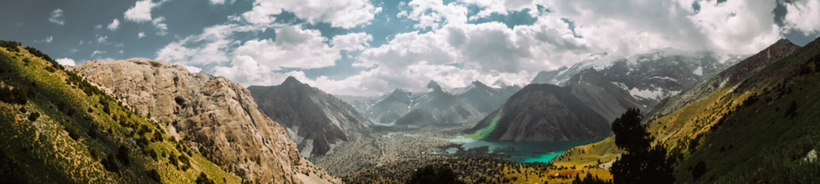 Tajikistan. Fann mountains. Summer. Beautiful mountain landscape. the mountains are covered with snow. Green-blue water (lake) Clouds weather Panoramic