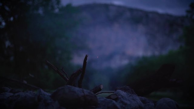 Campfire In The Texas Hill Country At A Campsite Along The Nueces River At Chalk Bluff Park. Placing Logs In The Fire Pit And Watching The Smoke.