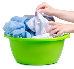 Green plastic bowl with laundry clothes in hand on white background isolation