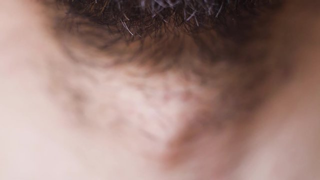 Macro footage of neck of young bearded man, selective focus