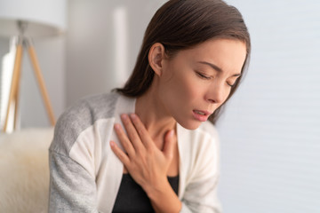 COVID-19 breathing difficulties woman with shortness of breath Coronavirus cough breathing problem. Asian girl in pain touching chest respiratory symptoms fever, coughing, body aches. - obrazy, fototapety, plakaty