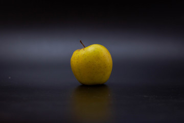 Yellow apple on a black background, vitamin D