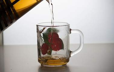 A teapot with tea is poured into a mug