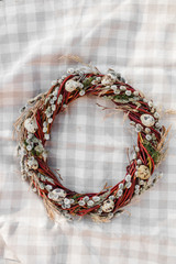 Easter wreath with quail eggs and moss on the background of a checkered tablecloth