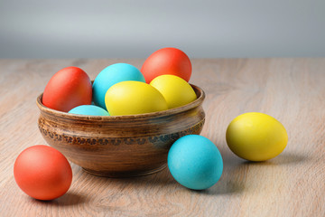 Colorful Easter eggs in brown pottery. Easter eggs are a symbol and a mandatory attribute of Easter.