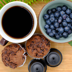 Freshly picked blueberries in bowl with cup of black coffee. Juicy and fresh blueberry with green leaves on rustic table. sparkleberry antioxidant. Concept for healthy eating