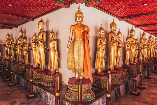 A line of Golden Buddha standing statues at Wat Pho Buddhist temple, Bangkok, Thailand.
