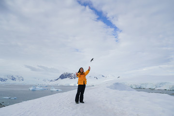 Woman Standing on Snow Bird Flying Overhead