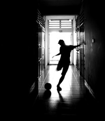 Silhouette Man Playing Soccer In Passageway