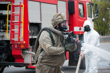 rescue team disinfecting street with special decontaminating liquid solution while covid disaster from fire engine