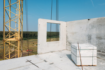 white concrete panel of a residential building during the installation of the top floor of an apartment building