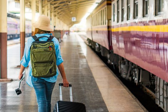 Solo woman backpacker traveler plan safety trip low cost budget summer holiday after coronavirus. Empty tourists on train railway platforms. Use bus train sustainable environmental friendly transport