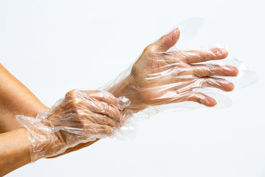 Senior woman's hands wearing disposable protective plastic gloves on grey background, Close up shot, Prevention from covid19, Coronavirus, Bacteria, Healthcare