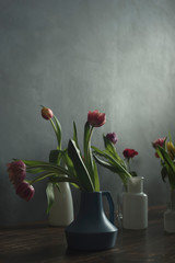 Blue and white vases with tulips on wooden table.