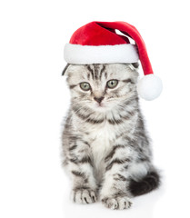 Fototapeta na wymiar Cute tabby kitten wearing a red christmas hat sits in front view. isolated on white background