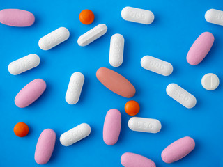 Colored pills on a blue background top view.