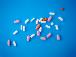 Colored pills on a blue background top view.